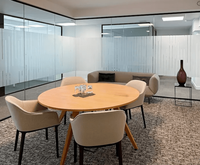 Moderner Besprechungsraum mit Glaswänden, Tisch und Stühlen